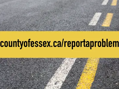 A yellow line over a road with yellow and white stripes and the words countyofessex.ca/reportaproblem