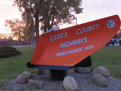 An orange plow blade that says Essex County Highways Maintenance Yard