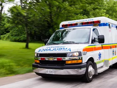 An Essex-Windsor EMS ambulance with a blurred background suggesting motion.
