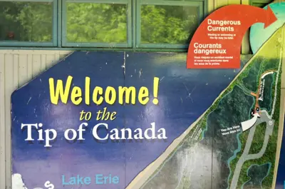 The welcome sign at the tip at Point Pelee National Park warns against swimming or even wading.