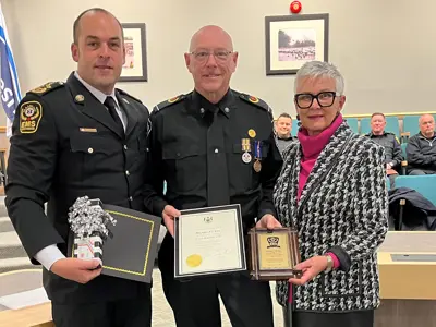 Essex-Windsor EMS Chief Justin Lammers and Warden Hilda MacDonald present retired paramedic Dan Pickel with certificates and a plaque.