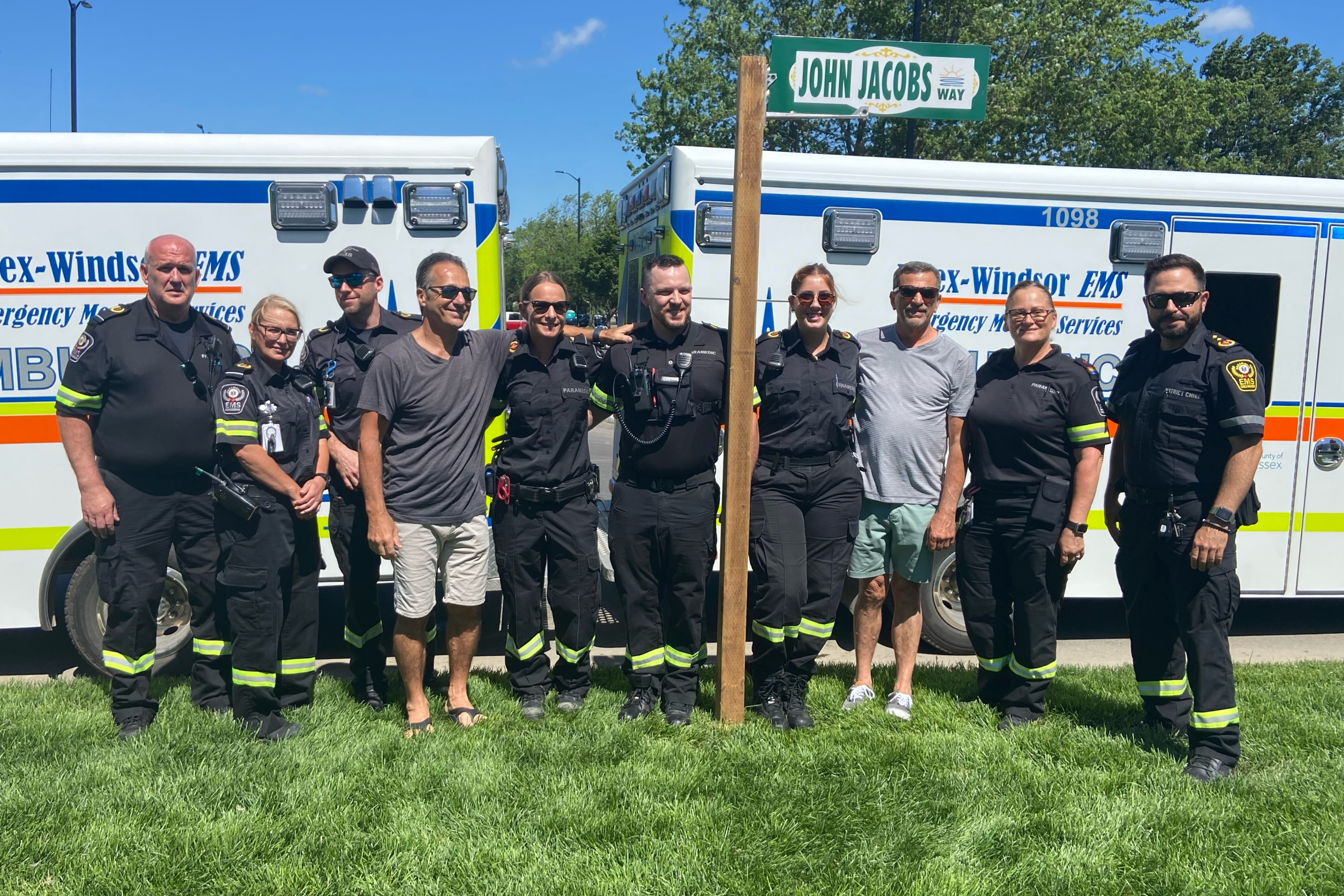 Paramedics gather at the new John Jacobs Way sign.