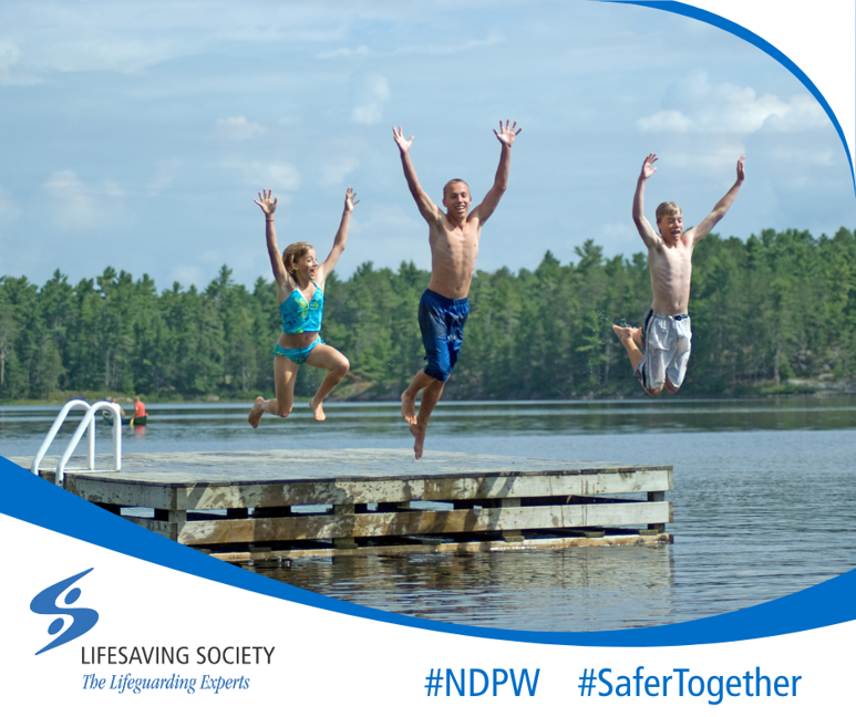 Three kids jump off a wooden deck into a lake.