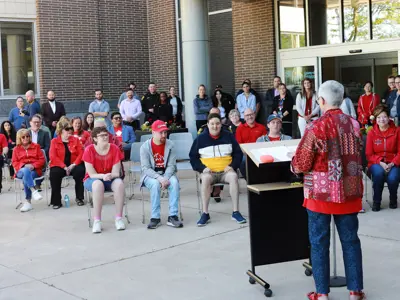 Warden Hilda MacDonald speaks to a crowd wearing red shirts at an Accessibility flag raising at the County of Essex Administration Building.
